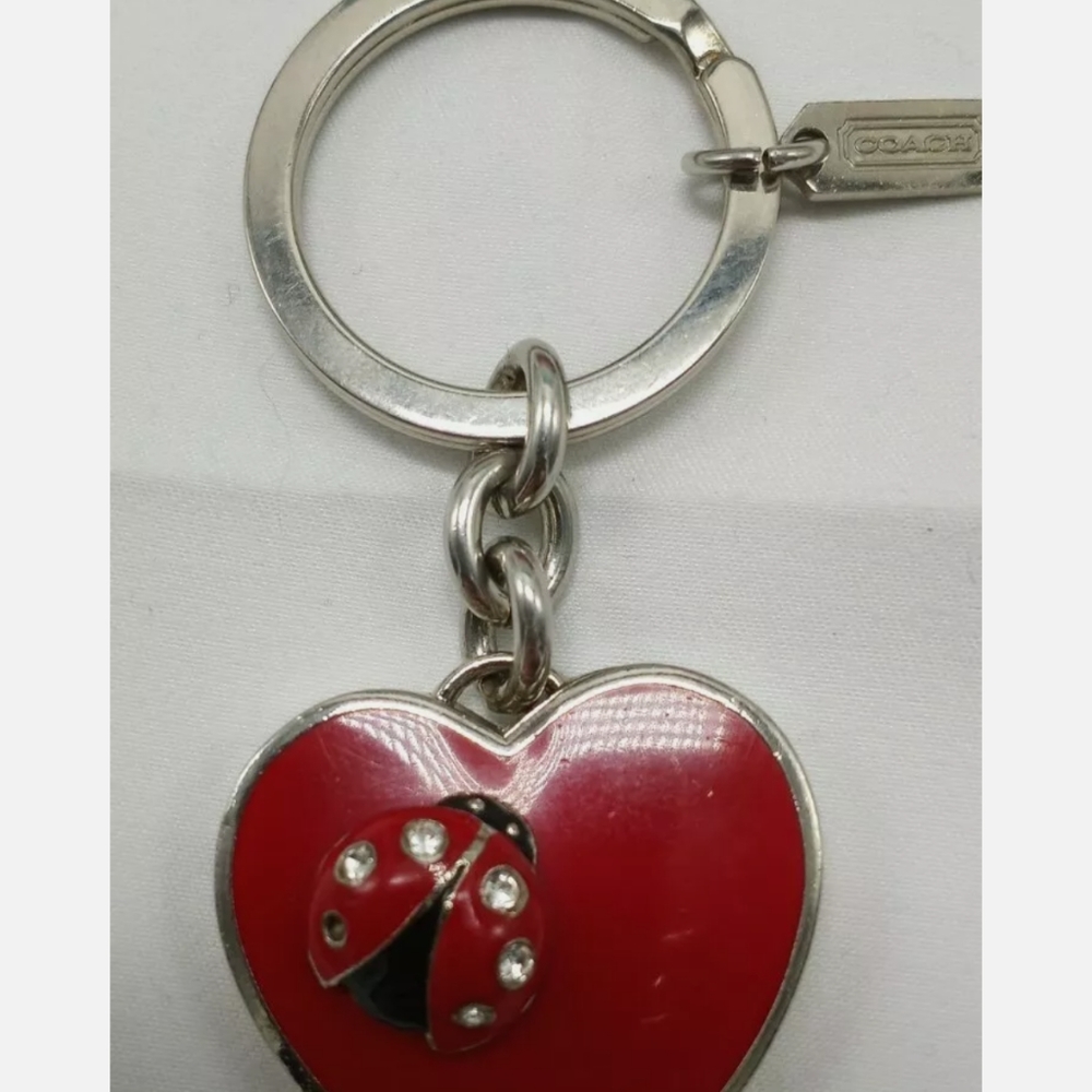 Coach branded heart locket keychain ladybug